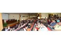 Panorámica de la mesa y de los numerosos asistentes a la conferencia